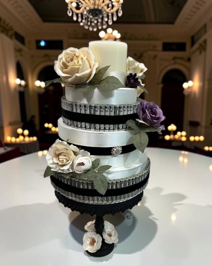 Ivory and black money cake with cream and purple roses