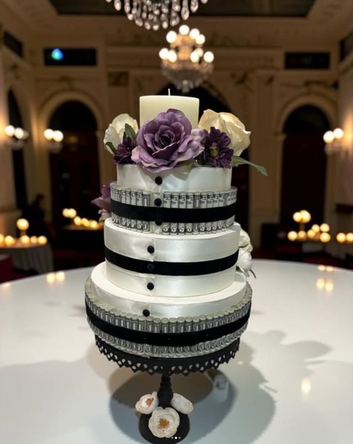 Tuxedo-style money cake with purple roses and a candle
